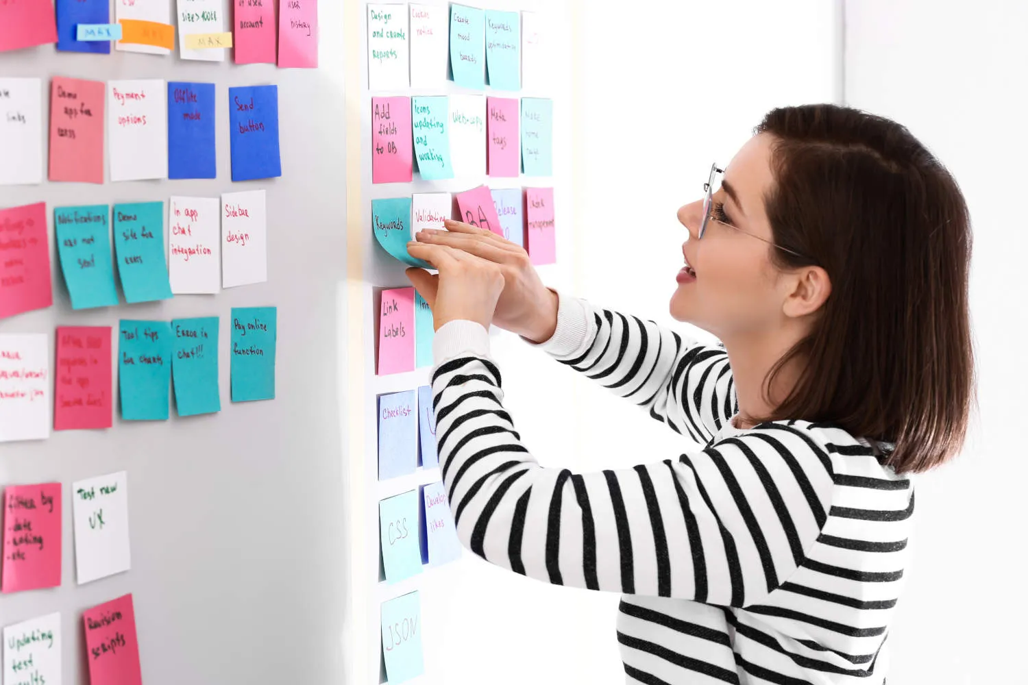 Frauen kleben Haftnotizen an die Wand